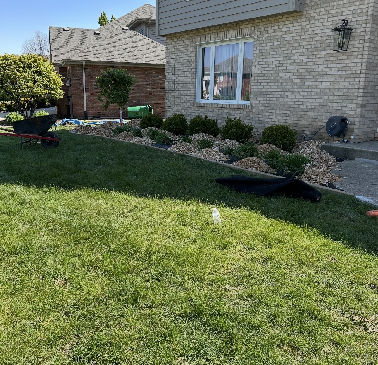 River rock landscape bed and shrub planting along a residential home